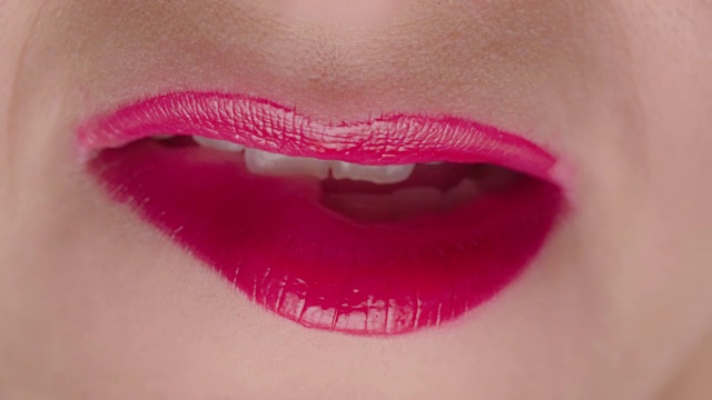 有吸引力的女性与红色口红咬嘴唇接近视频下载