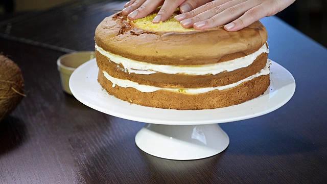 制作蛋糕的过程。糖果商用糕点抹刀将饼干奶油等量。视频下载