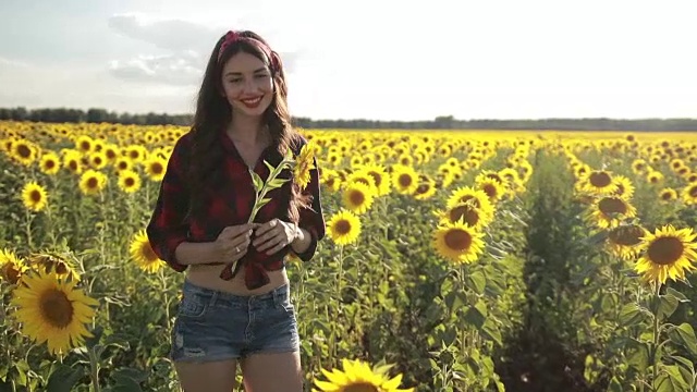 快乐的女孩带着向日葵享受大自然视频素材