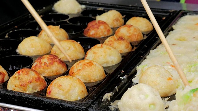 章鱼烧:一种用小麦粉做的面糊做成的球形日本小吃，在一个特制的模压锅里烹饪。视频购买