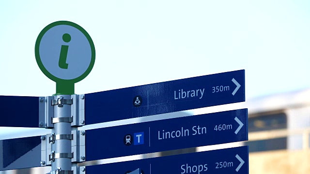 运动的城市方向信息标志与模糊的空中列车通过背景视频下载
