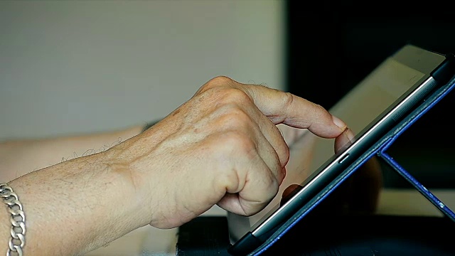 特写老人的手在家里使用平板电脑IPad视频素材