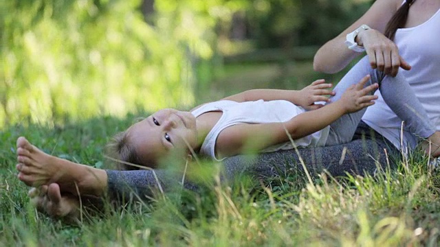 快乐的家庭妈妈和宝宝在户外玩耍，在绿色的公园里一起玩耍视频素材