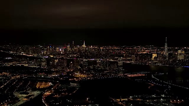 空中城市的灯光在晚上照亮新泽西和曼哈顿市中心的天际线视频素材