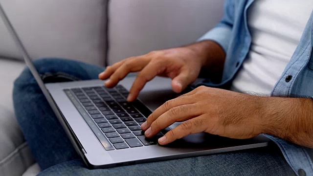 一个面目全非的人在笔记本电脑上工作视频下载
