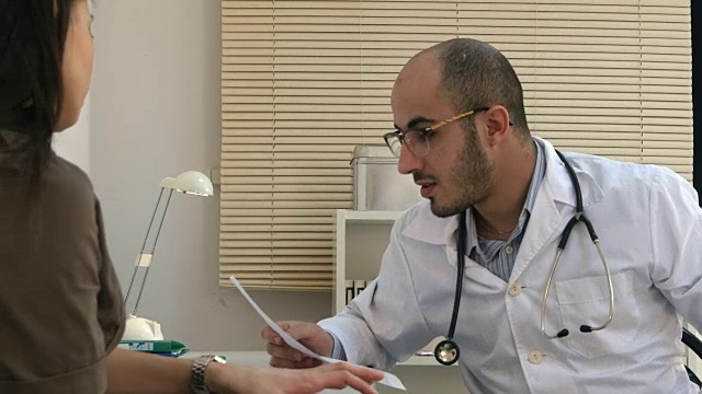 阿拉伯男医生向女病人解释心电图视频下载