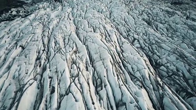 冰岛国家公园冰谷的顶部鸟瞰图。无人机飞过布满火山灰的白色冰川Vatnajokull视频素材