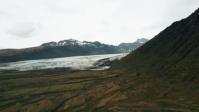 美丽的冰岛自然鸟瞰图。直升机绕山飞行，拍摄瓦特纳冰川融化的画面视频素材