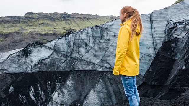 女游客欣赏被火山灰覆盖的冰岛冰川视频下载