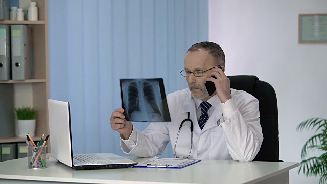 全科医生打电话给他的肿瘤医生同事讨论肺部x光视频下载