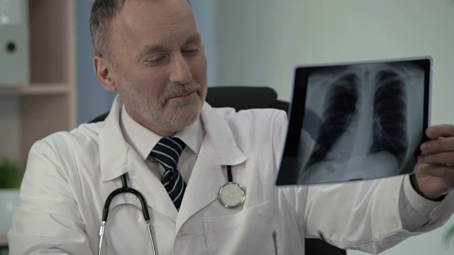 肿瘤学家看到x光，为病人从癌症中恢复而高兴视频素材