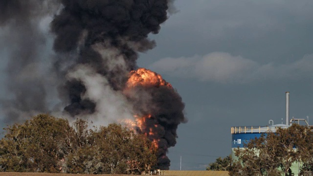 炼油厂事故-巨大的爆炸和火球上升。浓重的黑烟笼罩着天空。视频下载