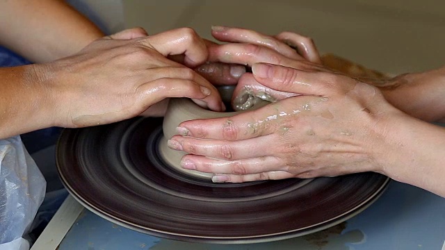 两个人的双手创造出锅，陶工的车轮。教学陶器视频素材