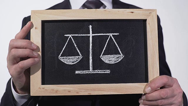 在律师手中的黑板上画着正义的天平，决定利弊视频下载
