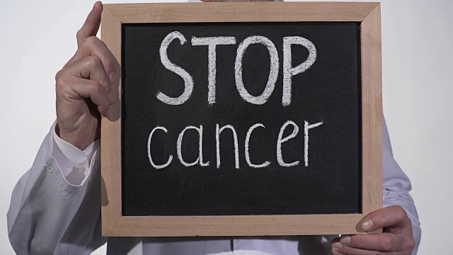 在医生手中的黑板上停止癌症文字，疾病治疗创新视频下载
