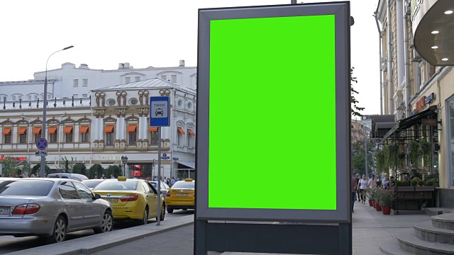 繁忙街道上的一个绿屏广告牌。视频素材