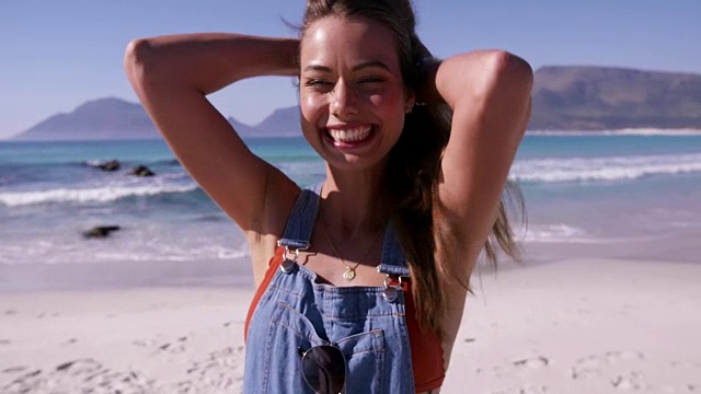 时髦的年轻女子享受在海滩上的一天视频下载
