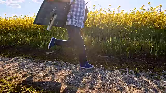 一个穿着喷气背包的小男孩在土路上奔跑视频素材