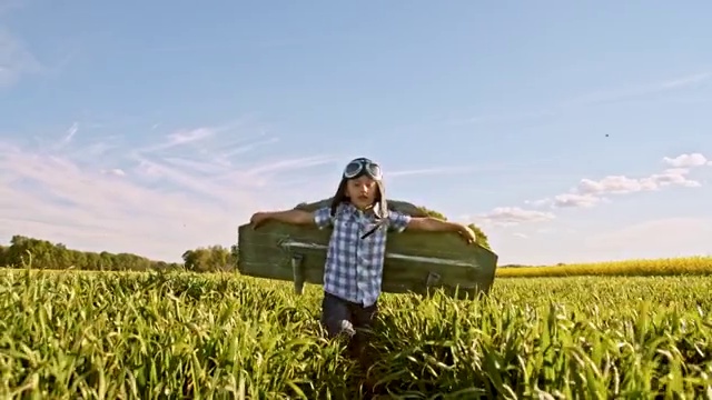 小男孩穿着喷气背包的服装在麦田里奔跑视频素材