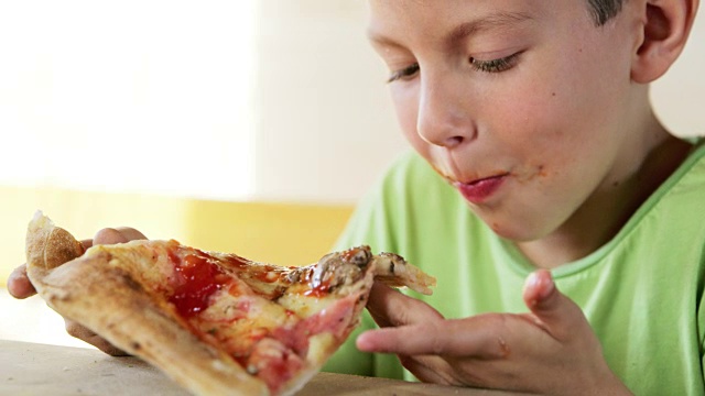 CU男孩在吃披萨视频素材