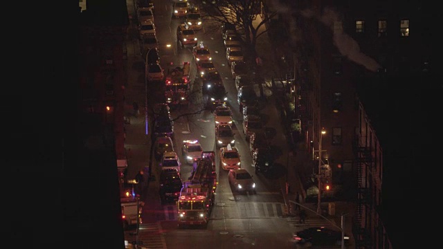 鸟瞰图消防车站在一个城市的街道在夜晚。汽车，交通，警示灯视频素材