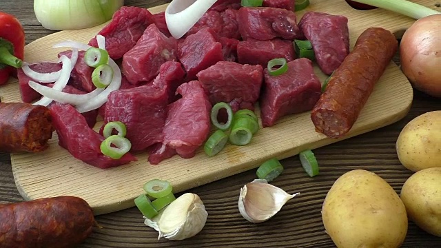 用牛肉和蔬菜做炖牛肉。砧板上的新鲜生肉视频素材