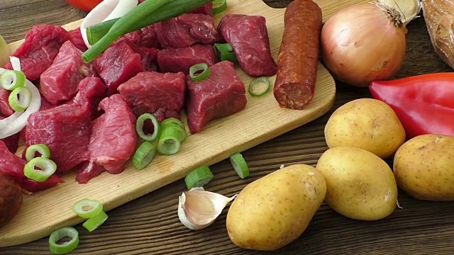 用牛肉和蔬菜做炖牛肉。砧板上的新鲜生肉视频素材