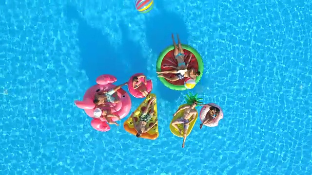 航拍:快乐的人们在游泳池里玩充气球视频素材
