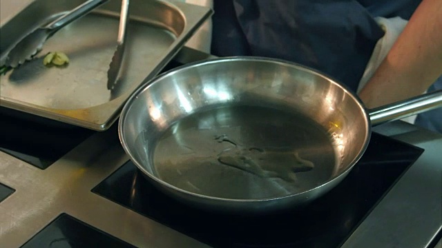 厨师用平底锅煎大蒜和香草视频素材