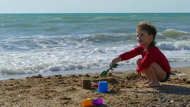 小男孩在沙滩上玩耍，在沙滩上吹牛视频下载