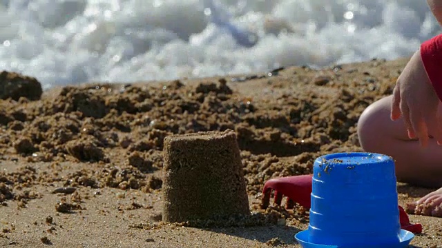 小孩子在沙滩上玩玩具做沙视频下载