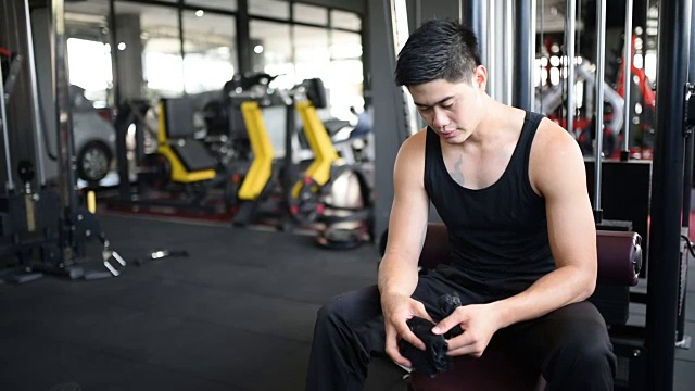 亚洲男性健身戴手套在健身房玩杠铃视频素材