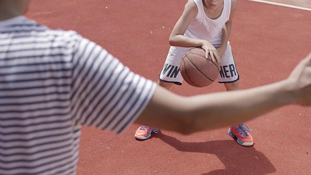 亚洲男孩在球场上打篮球的慢镜头视频下载