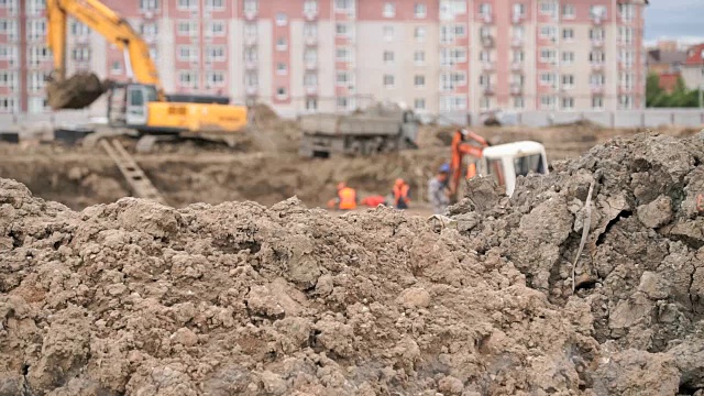 建筑工人们在一个大的粘土坑里施工视频下载