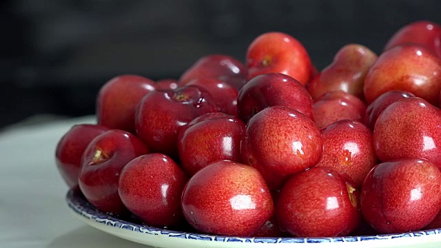 鲜红的樱桃堆在食物背景上旋转。樱桃果实视频素材