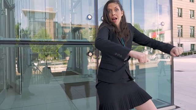 一位女商人在办公楼外疯狂地跳舞庆祝她的成功视频素材