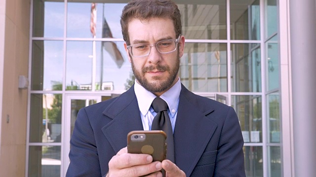 商务人士与智能手机应用技术和微笑在办公楼外视频素材