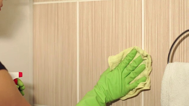 特写的女孩在手套清洁瓷砖表面。视频素材