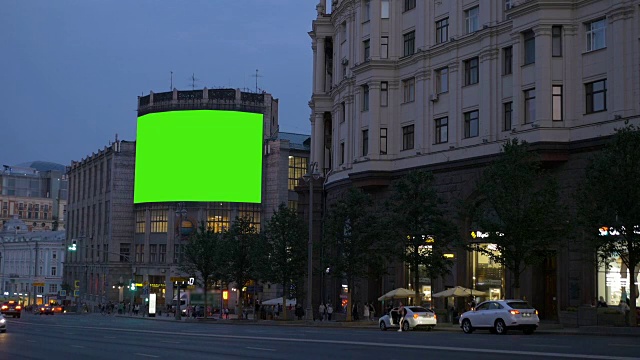 一个有绿色屏幕的广告牌在繁忙的街道上。视频素材