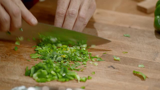 一个男厨师的手正在木板上切新鲜的绿色香草视频素材
