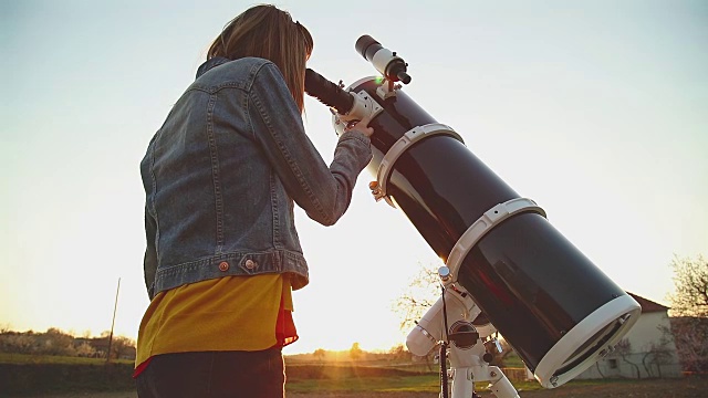 用望远镜看星星的女孩。视频素材