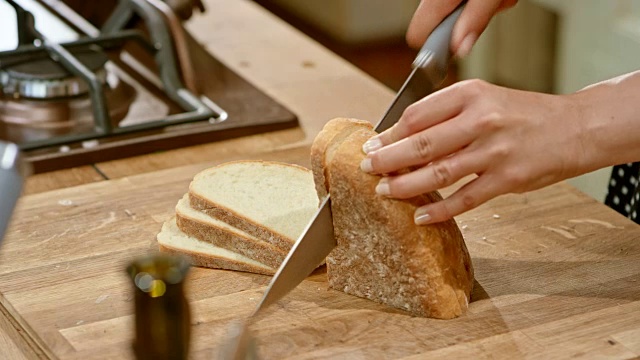 女人的手在木板上切面包视频素材