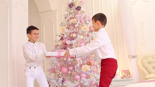 孩子们的欢乐油炸和兄弟们的战斗，在卧室的新年礼物与圣诞树视频素材