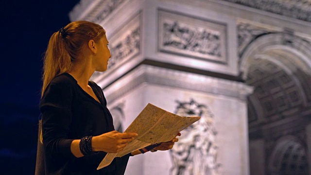 带着巴黎城市地图的游客在夜间欣赏凯旋门纪念碑视频素材