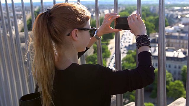 游客在凯旋门上拍摄巴黎的照片视频素材