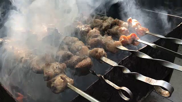 美味的烤肉串是在烟中在火上烤的视频下载
