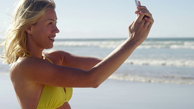 在海滩上用手机自拍的女人视频素材