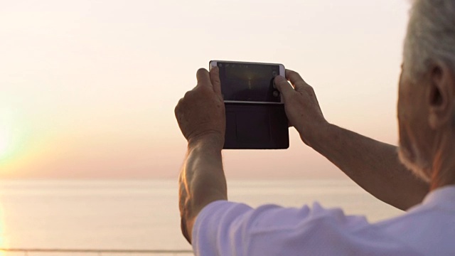 中年男子在海上拍摄日出照片视频下载