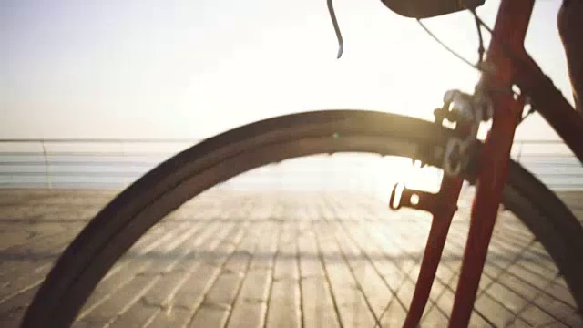 帅气的老男人骑着自行车在海边，慢动作，近景，慢动作视频素材