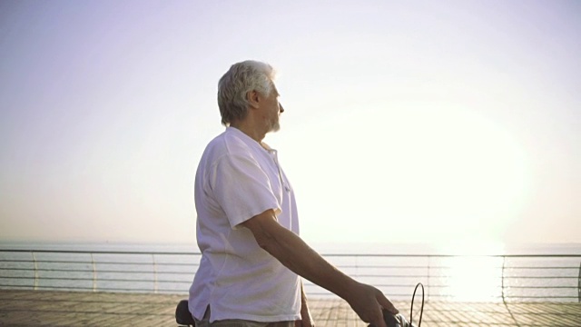 在海边骑自行车的帅老头的肖像视频素材